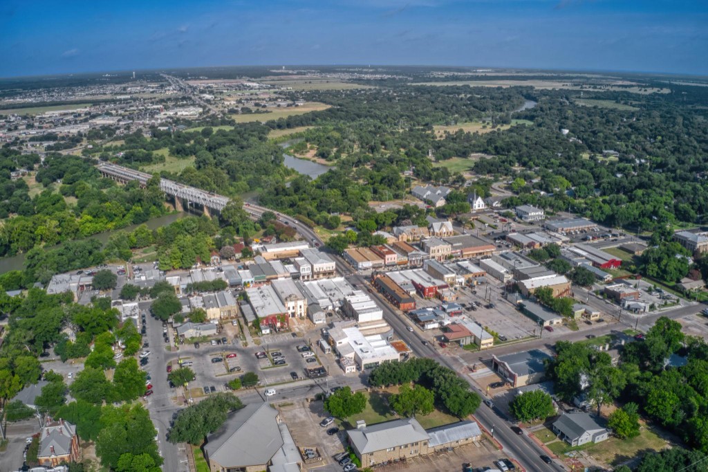Aerial view of downtown Bastrop, the river bridge, and the surrounding pines